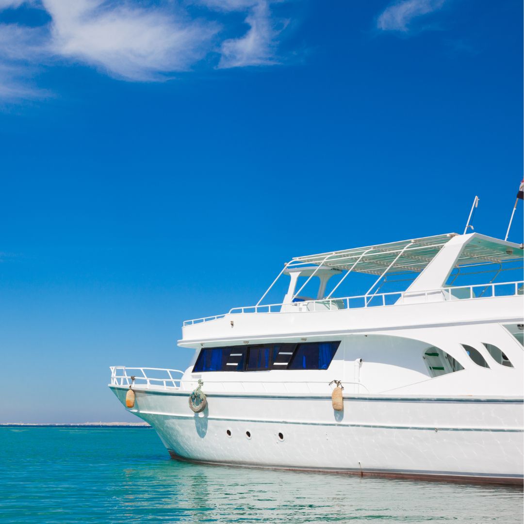 Luxury yacht anchored in clear blue water, showcasing modern design and pristine condition, symbolizing TESS, LLC's electrical services for yachts in Barcelona.