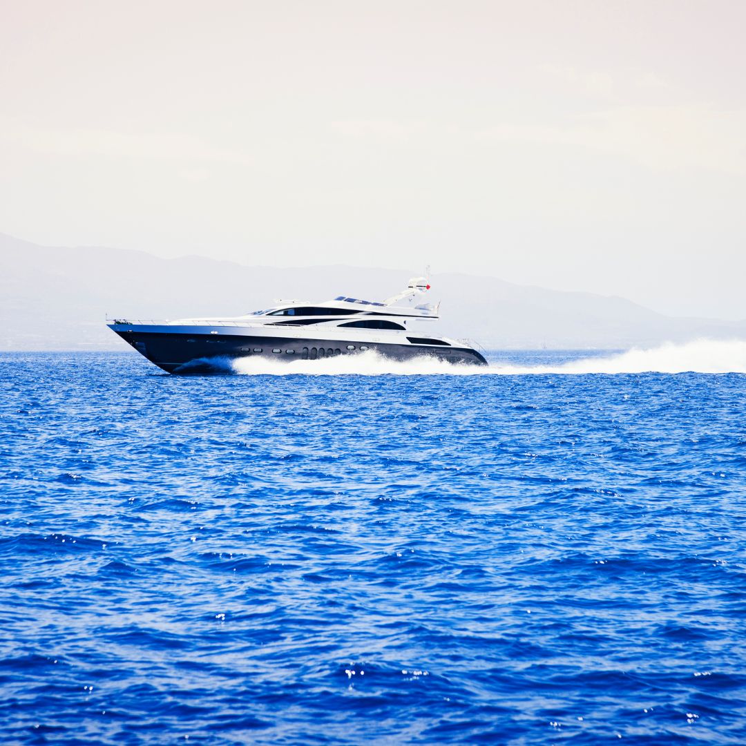 Luxury yacht cruising through vibrant blue waters, showcasing modern design and performance, relevant to TESS, LLC's innovative electrical solutions for yachts in Barcelona.