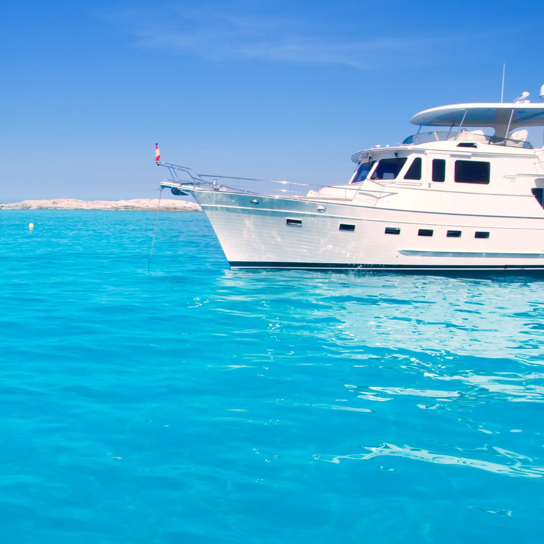 Luxury yacht anchored in vibrant turquoise waters, showcasing TESS, LLC's expertise in marine electrical services for yachts in Monaco.